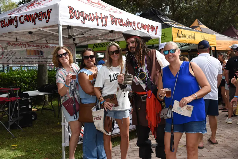 Costumed pirate host posing with a group of festival attendees