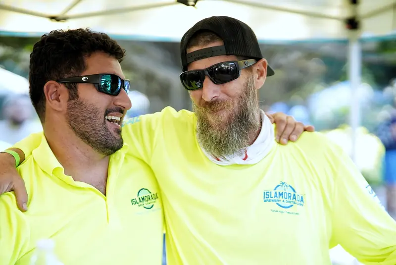 Brewers close together under neon lights at the festival