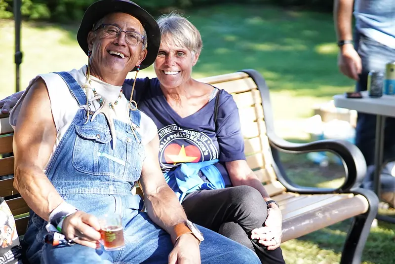 Couple relaxing on a bench in the park during the festival