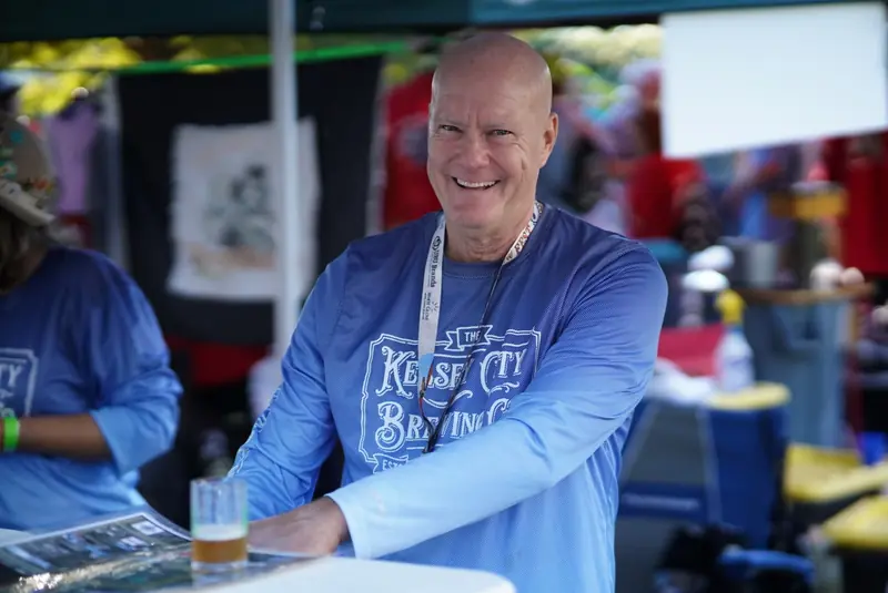 Brewer working the booth and pouring samples